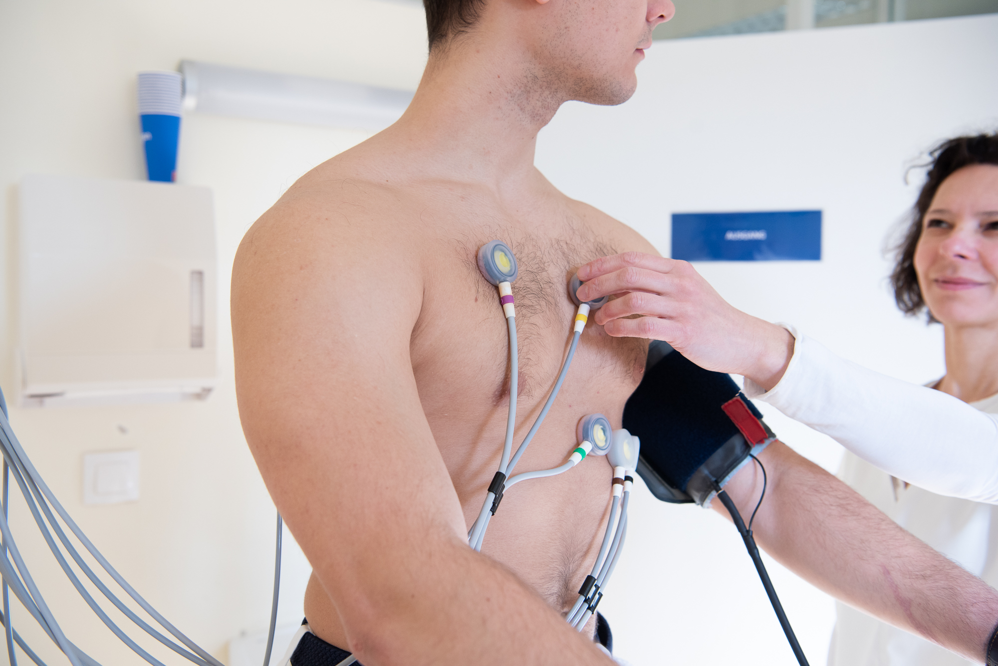 Dr. Schieder mit einem jungen Patienten beim EKG. Die beiden blicken sich an.