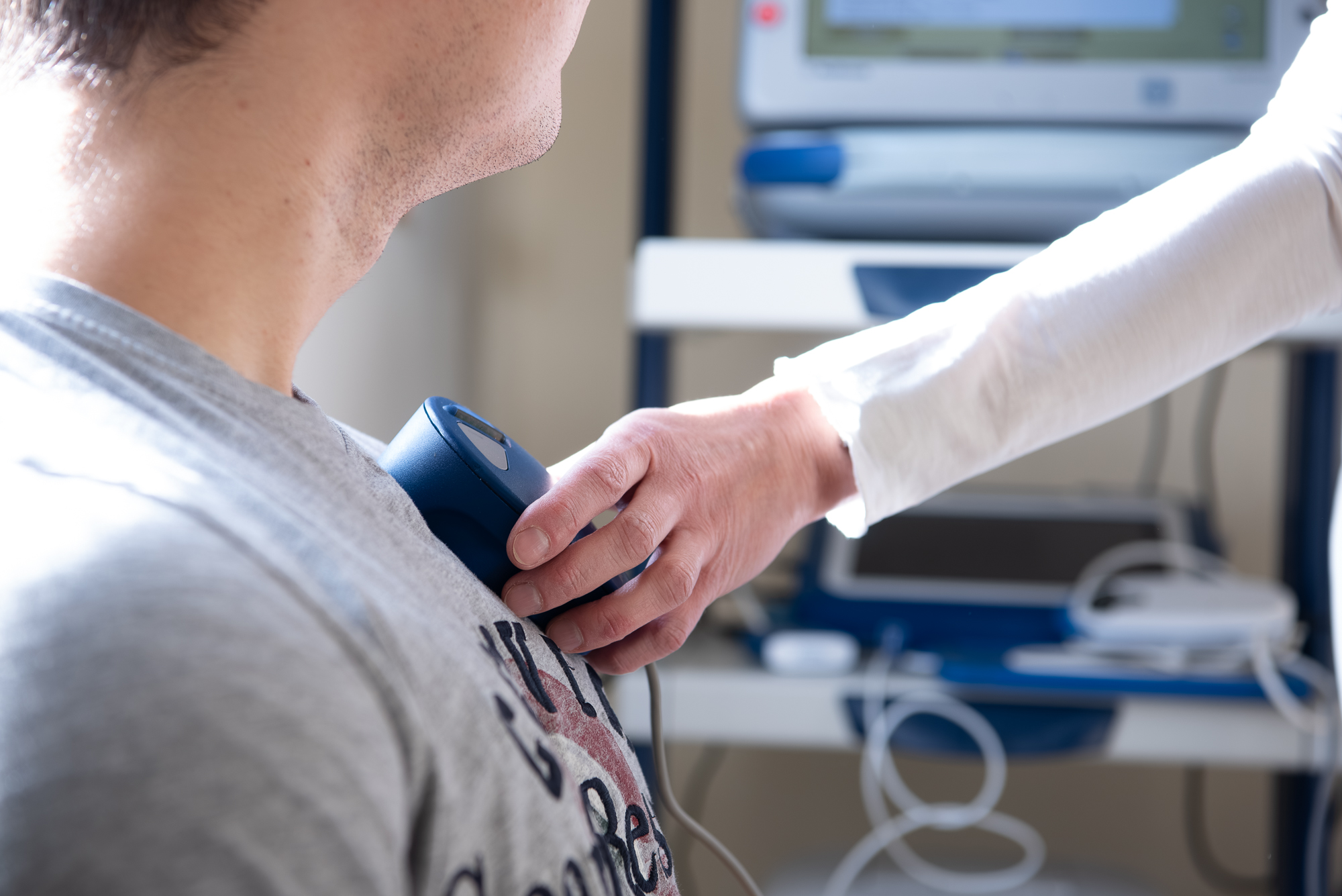 Oberkörper eine Patienten mit dem Kontrollgerät für die Schrittmacherkontrolle in der Hand der Ärztin