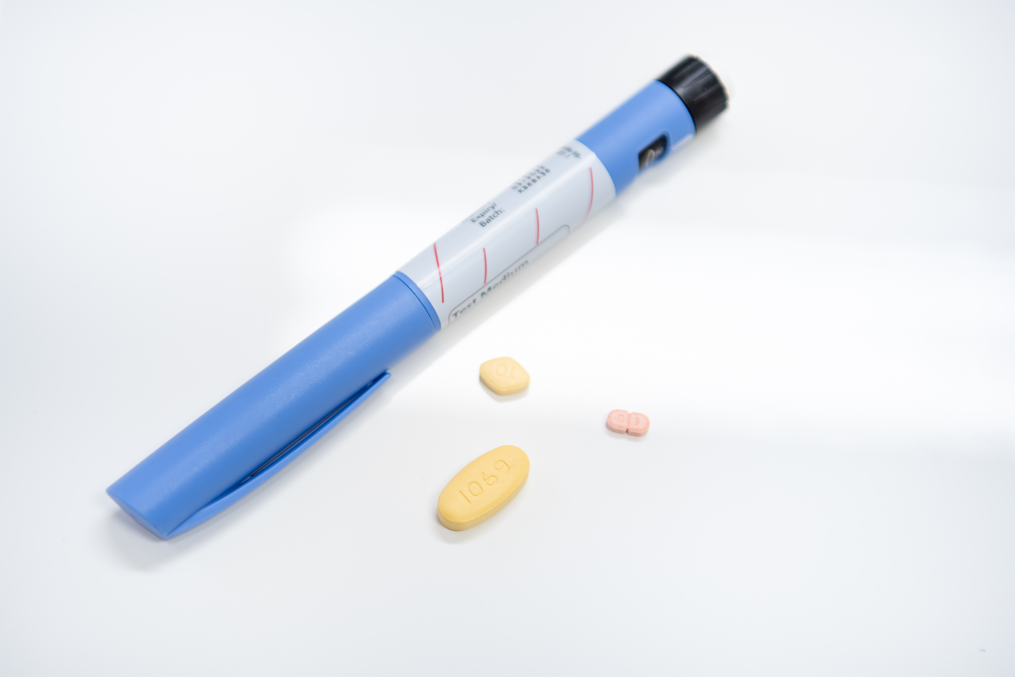 eine Diabetesspritze und drei verschiedene Tabletten